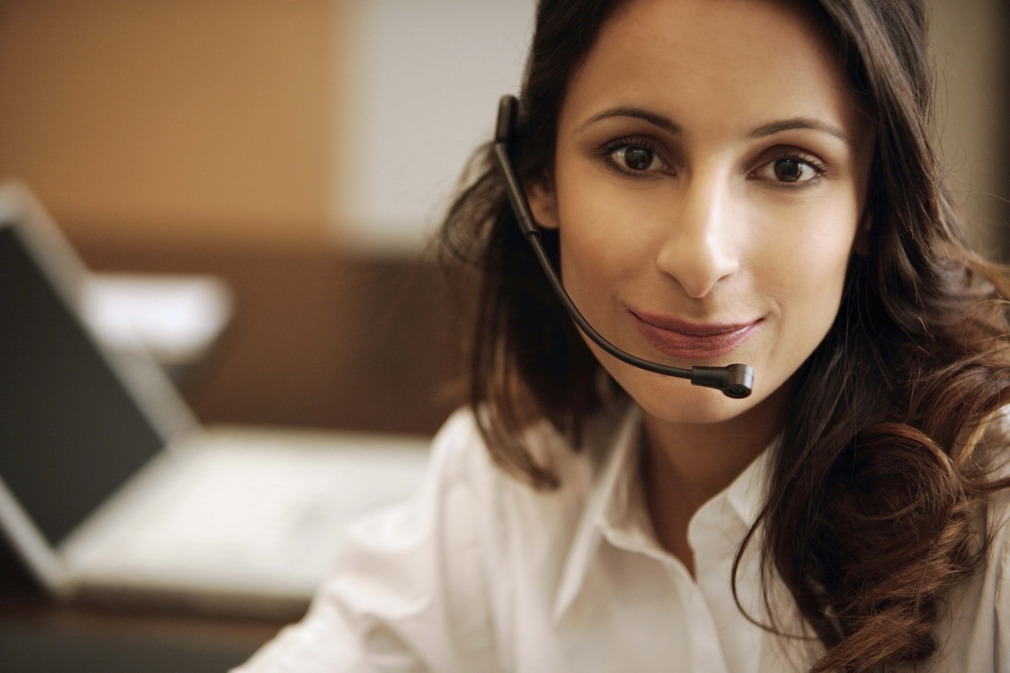 A smiling woman wearing a phone headset.