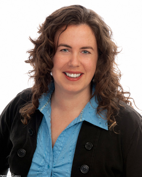 A headshot of a young woman with a bright smile and curly hair.