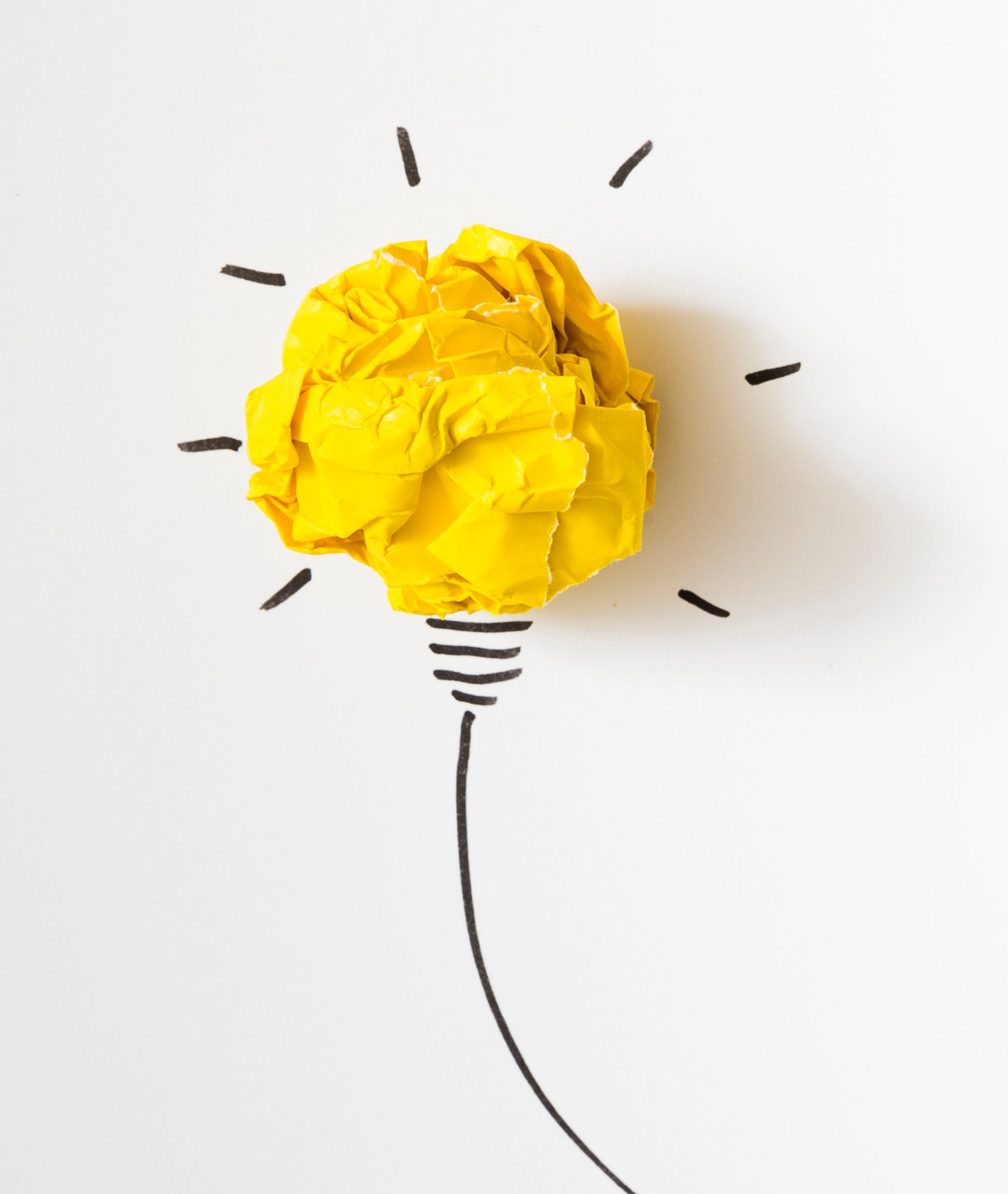 Image shows illuminated lightbulb with crumpled yellow paper used in the bulb's place and the rest drawn in black on a white background.