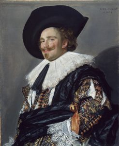 Painting by Frans Hals titled The Laughing Cavalier. The man in the painting has an elaborate moustache, and is wearing a large black, wide-brimmed hat, lace collar, embellished shirt with slash sleeves and belly sash.