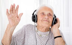 Photograph of elderly person wearing headphones enjoying music