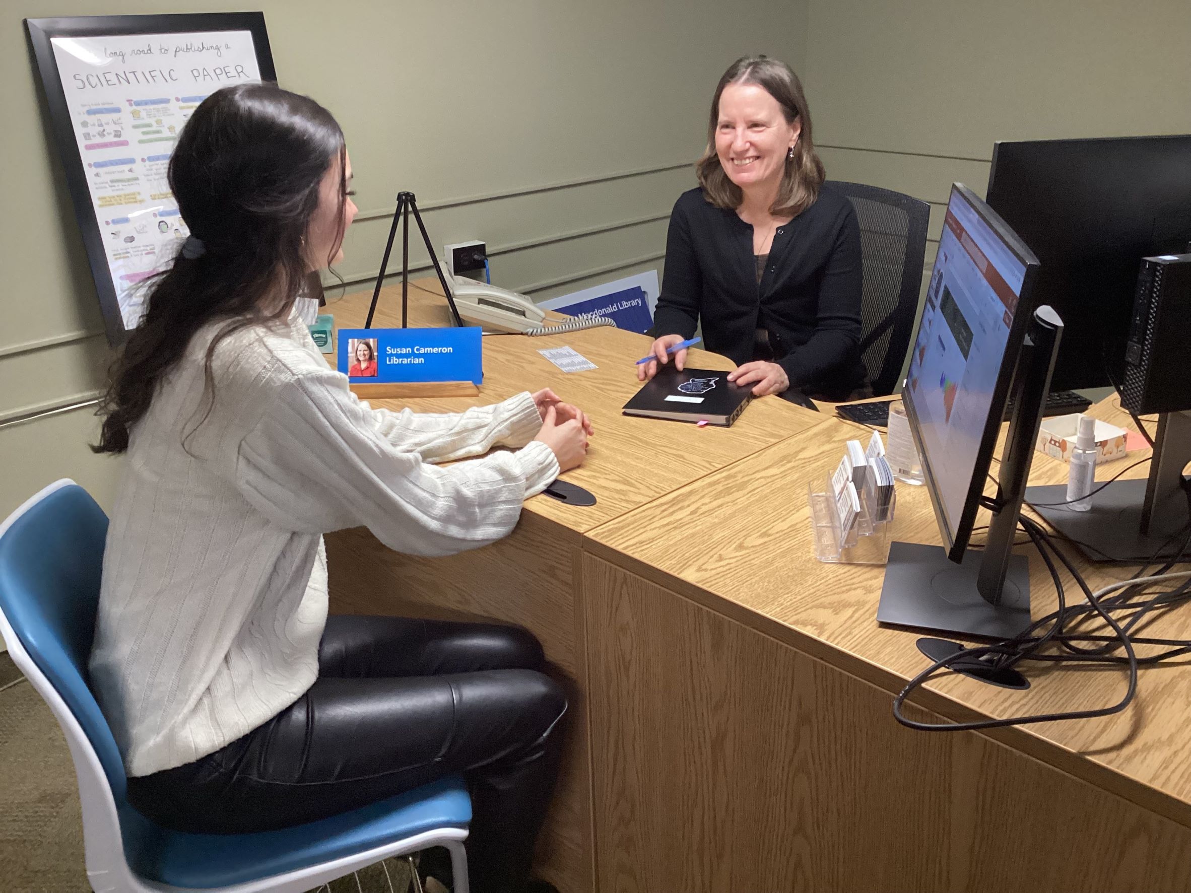 Photo of student and librarian at the Research Help Desk